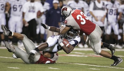 UNLV linebackers Nate Carter, left, and Jason Beauchamp tackle UNR running back Courtney Randall during the second half of Saturday's game at Sam Boyd Stadium.