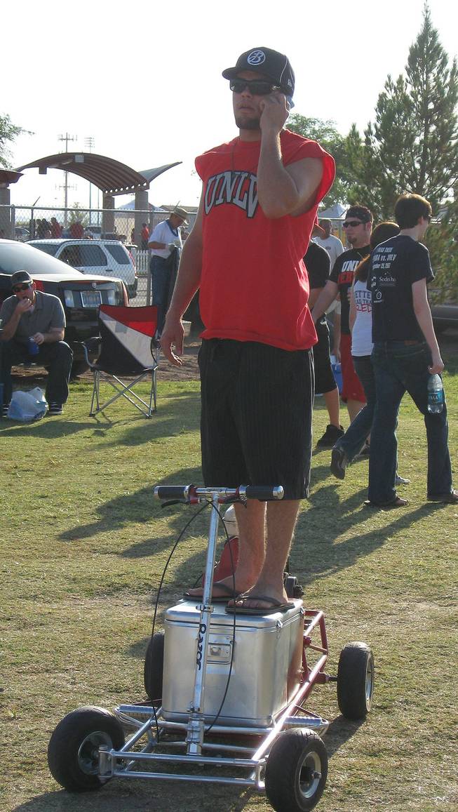  Rebels fan Robby Diaz takes in Saturday's tailgating scene before the Silver State showdown from atop his gas-powered "go-cooler."