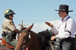 Richard Howes, president of the Single Action Mounted Shooting Club, right, talks with Metro Officer Kelly Korb during the eighth-annual Pony Express Shoutout at Henderson Saddle Association Park on Saturday.