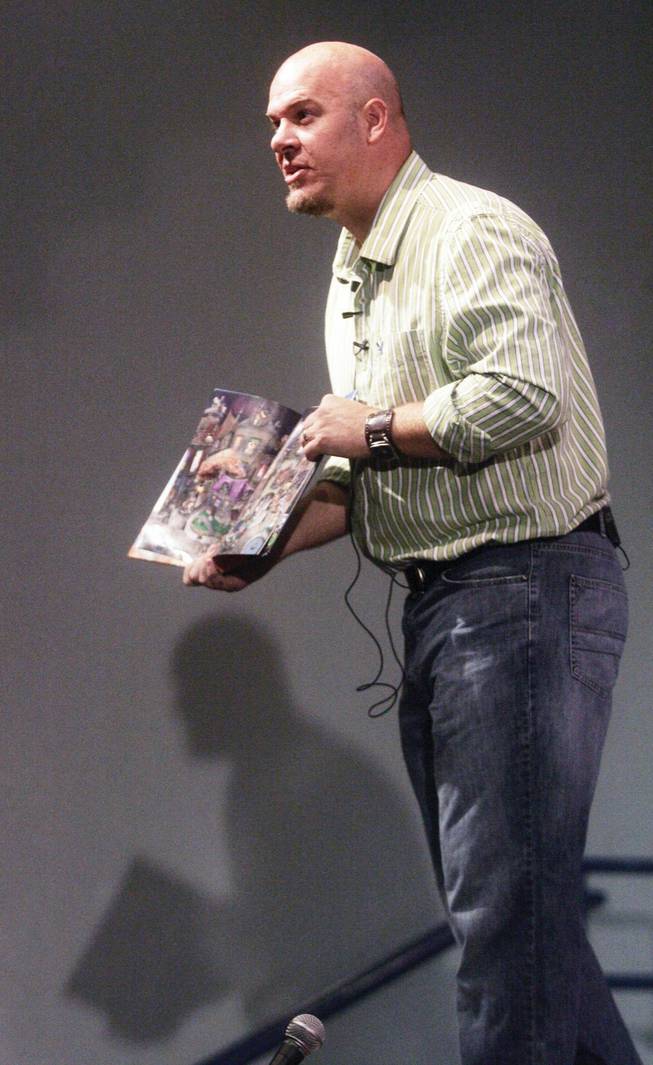 Children's author and illustrator, Mark Ludy, shows the illustrations of his wordless book, "The Flower Man," to art students at Basic High School on Sept. 22.