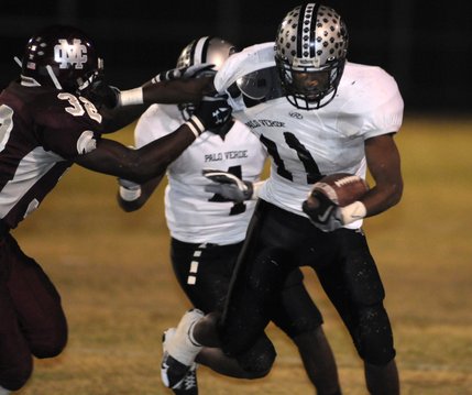 Panthers running back Tyrone Blake (11), right, attempts to escape the clutches of Spartan defender Roderick Washington (32) during Friday's game at Cimarron-Memorial High.