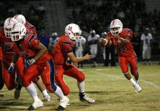 Liberty's Ryan Doty (10) pitches to running back Shawn Murray (11) during Friday's homecoming football game against Basic.
