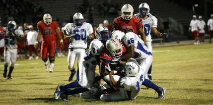 Basic's defense tackles Liberty's Sage Nua (45) during Friday's game.