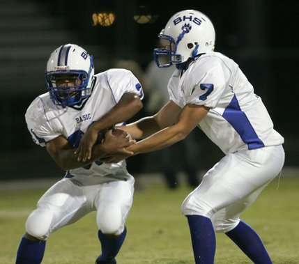 Basic quarterback Robby Faiman (7) hands off a pass to Charles Phillips (31) during Friday's away game against Liberty.