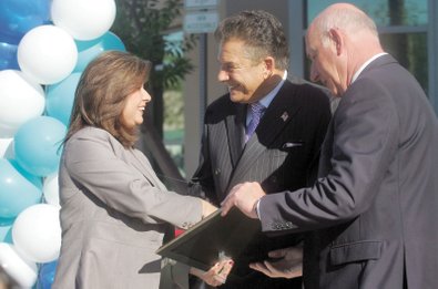 From left to right, Councilwoman Gerri Schroder presents Steve Schorr and Cox Communications Senior Vice President and General Manager Leo Brennan with a certificate of congratulations from the City of Henderson during the Cox Communications Henderson Retail and Payment Center opening Oct. 6.  The facility was moved from its Water Street location to the northeast corner of Stephanie Street and Warm Springs Road to meet growing demand.  