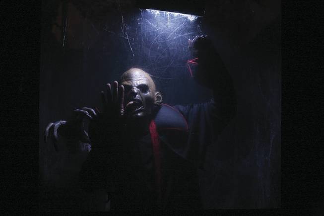 A zombie beats on the glass towards haunted house goers at Fright Dome in Circus Circus.