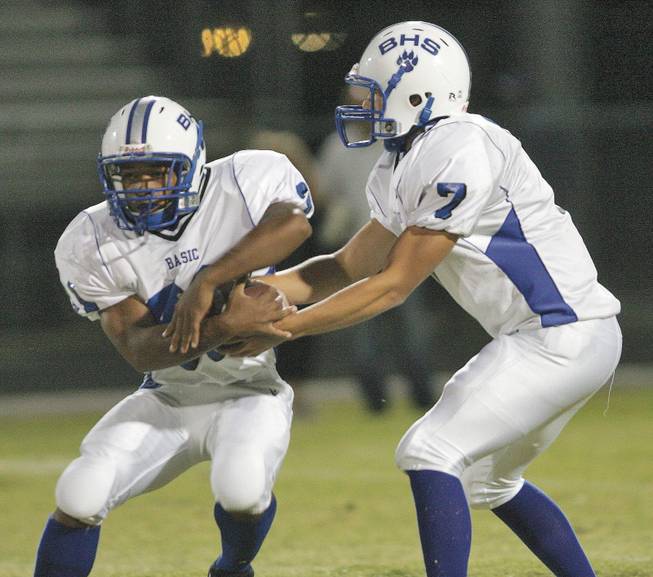 Basic quarterback Robby Faiman (7) hands off a pass to Charles Phillips (31) during an away game against Liberty on Friday, Oct. 3, 2008.