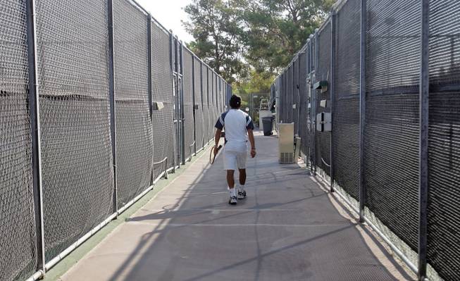 Tennis director Sam Aparicio walks down a row of tennis courts to get supplies for a tennis lesson at the recently reopened Spanish Oaks Tennis complex.