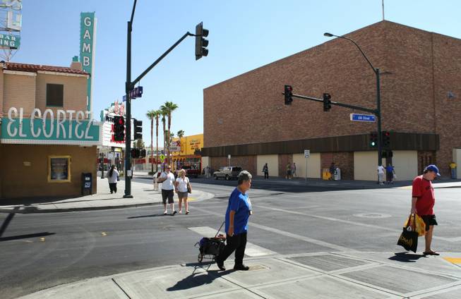 Pedestrians pass by a vacant building, right, at the corner of Fremont and Sixth streets in downtown Las Vegas. A European billionaire who collects contemporary art wants to convert the building into 23,000-square-foot museum. The proposal by Tamares chief executive Poju Zabludowicz of Lichtenstein, is one of four projects the city is considering. 