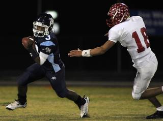 Bulldogs quarterback Chris Henderson (3) looks to evade Arbor View's Austin Anderson (18) during Friday's game at Centennial High.