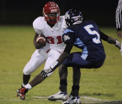 Aggies running back Taylor Wooten (31) looks to evade Bulldogs tackler Jeremy Howard (5) late in the first half of Friday's game at Centennial High.