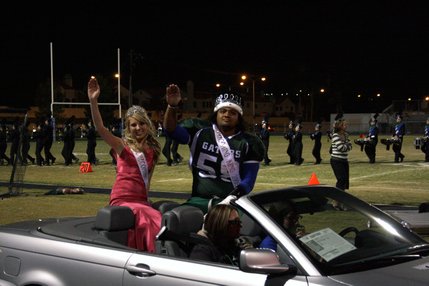 Homecoming queen Lexi George and king Brigham Tauteoli ride around the football field during Green Valley's homecoming football game.