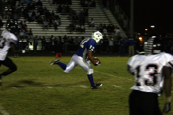 Basic's Justin Burdno runs with the ball during Friday's game ...