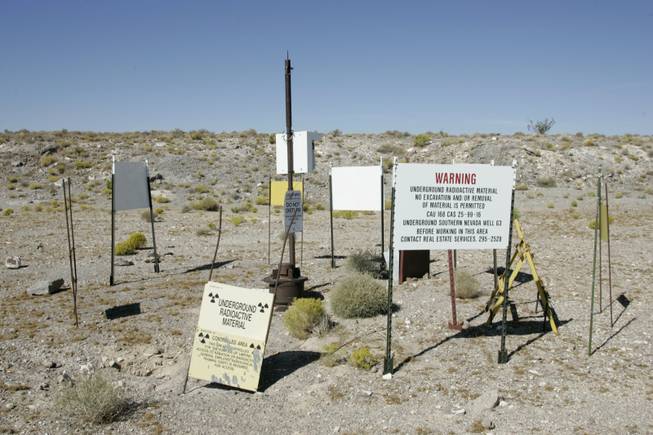 Atop Yucca Mountain, 90 miles northwest of Las Vegas, signs warn of possible radiation near a test well. 