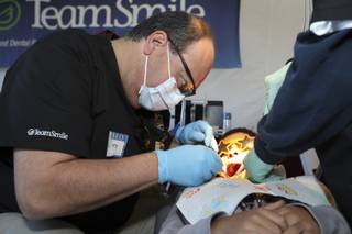 Dr. James Frantz of Green Valley examines third-grader Jason Thom's teeth in the 