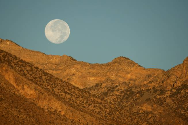 A full moon sets over the mountains at sunrise Wednesday, Oct. 15, 2008. The view is  from Summerlin Parkway and the I-215 Beltway.