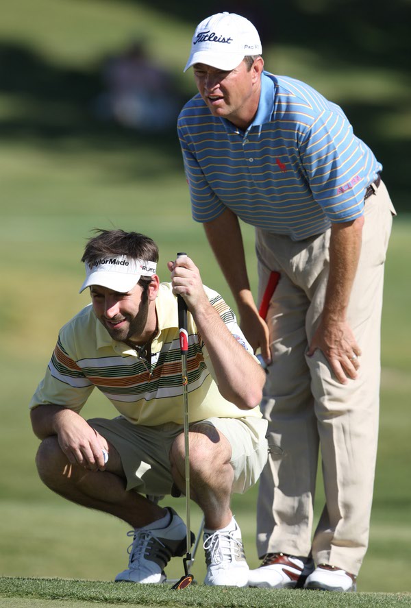 Singer Josh Kelley (left) lines up a putt with help ...