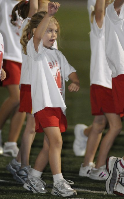 Kelsey Goddard, 5, performs a cheer with other members of the 