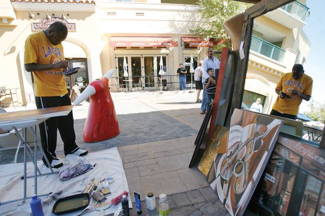 Artist Mandell Maull adds more paint to his brush while painting acrylic on canvas during the sixth-annual Fall Arts Festival at the Montelago Village at Lake Las Vegas on Oct. 18.