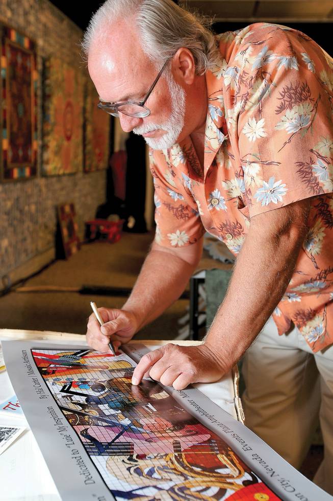 Mosaic artisan Hal Carter autographs a print of his mural "Artistic Freedom" for a fan during the unveiling reception in his honor Friday at the Henderson Events Plaza.