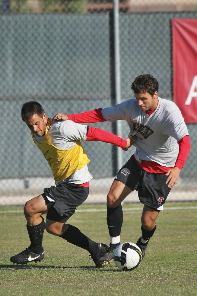 UNLV's outside midfielder, Zac Zaher, right, vies for the ball against forward Daniel Cruz during a team practice.