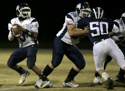 Centennial quarterback Chris Henderson drops back for a pass at Friday night's game.