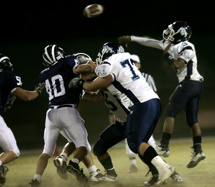 Centennial quarterback Chris Henderson jumps over the Shadow Ridge line to get the pass off.