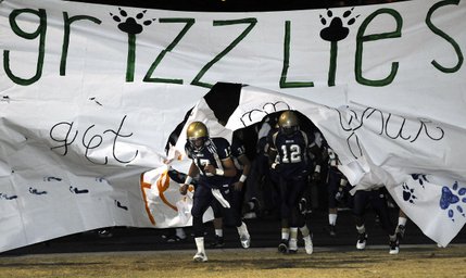 Alex Quintero (17) and Anton Stallworth (12) lead the Grizzlies onto the field before the start of Friday's home game against Bonanza.