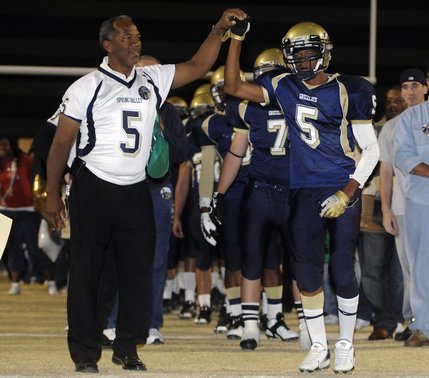 Kennedy Sanders, left, stands beside his son, Keenan, during a salute to Spring Valley's senior players and their families before Friday's game against Bonanza.