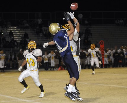 Bonanza's Aaron Simon (4) breaks up a pass intended for Spring Valley receiver Brandon Lopez (11) during a game Friday at Spring Valley High. Closely watching the play at left is Bonanza's Alex Seguin.