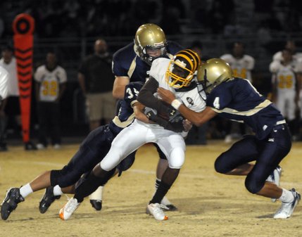 Bengals receiver Chris Robertson (24) is wrapped up by three Grizzly defenders after catching a short pass at the end of the third quarter of Friday's game at Spring Valley High.