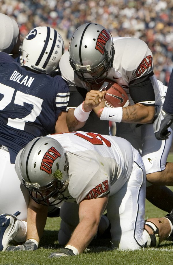 UNLV quarterback Mike Clausen takes the ball past BYU defensive ...