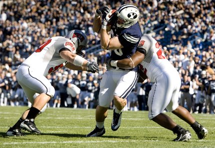 BYU tight end Andrew George catches the ball between UNLV linebacker Rusty Worthen, left, and UNLV defensive back Wiselet Rouzard to score during the first quarter on Saturday, Oct. 25, 2008, in Provo, Utah. 