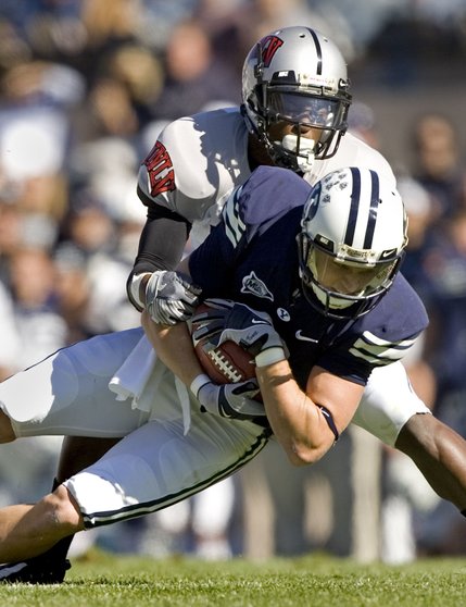 BYU wide receiver Austin Collie (9) lunges for extra yardage as he is taken down by UNLV defensive back Daryl Forte (8) during the first quarter on Saturday. 