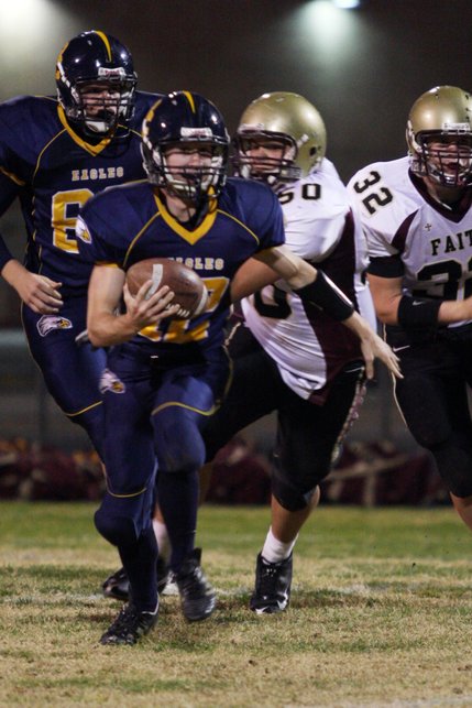 Boulder City quarterback Jake Phillips makes a run past Faith Lutheran players at a home football game on Friday.
