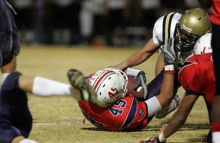 Liberty's Sage Nua, left, pushes Foothill's Dillion Armstrong, right, as they fall to the ground during the fourth quarter Friday night. Liberty lost to Foothill, 14-16. 