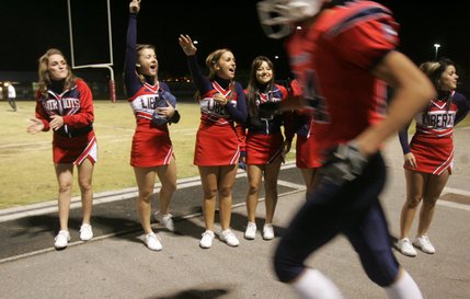 Liberty cheerleaders pump up the crowd as players run onto the field in the second half of Friday's game against Foothill. 