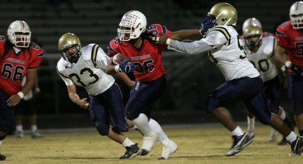Liberty's Jordan Kapeli, center, pushes past Foothill's Andrew Brown, left, and Izach Lucas, right, during a game at Liberty High School Friday night. Liberty lost to Foothill, 14-16. 
