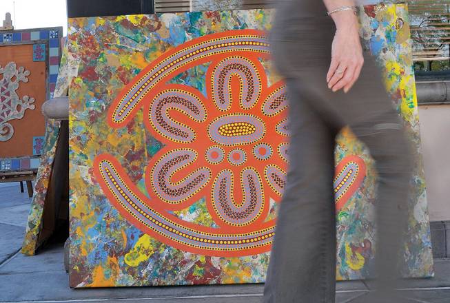 An art browser strolls past mosaic wall art by Hal Carter during the second day of the Art Walk at Trails Village Center.