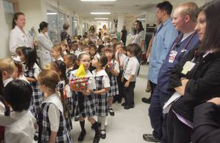Kindergarten students from The Meadows line the halls of the UMC pediatric intensive care unit carrying decorated pumpkins for patients on Wednesday.