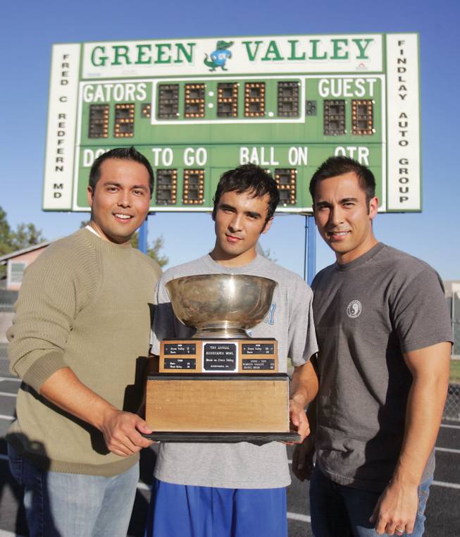 From left to right, brothers, Nick, Taylor, and Ian Jones hold the Henderson Bowl at Green Valley High School on Oct. 23.  All three brothers played on the Green Valley football team and participated in the annual Henderson Bowl against Basic.  
