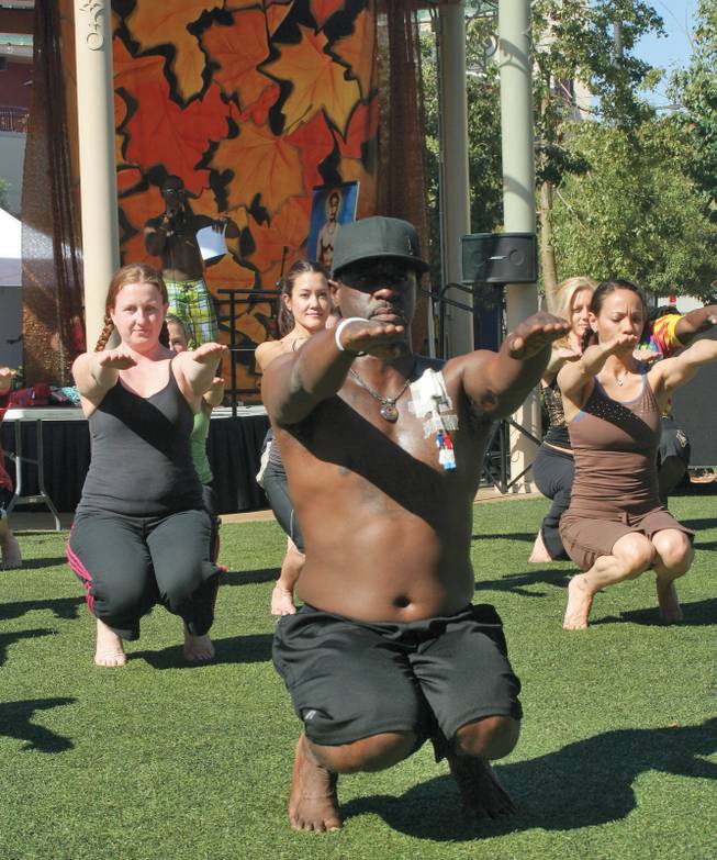 George McLaurin, center, who has used bikram yoga to help survive a kidney transplant, leads the bikram yoga demonstration during the annual Bishnu Ghosh Yoga competition at Town Square Park.