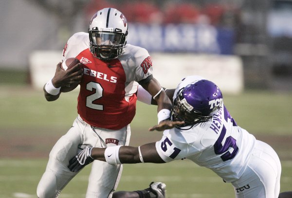 UNLV quarterback Omar Clayton pushes off TCU linebacker Robert Henson ...