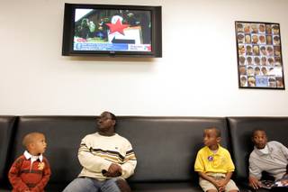 From left, Furious Hoskins, 3, Corey Carter, 22, Darryl Jones, Jr., 11, and Trevon Latchinson, 8, wait for hair cuts on election day at Executive Cuts in Las Vegas. CNN plays election coverage on the television above. 