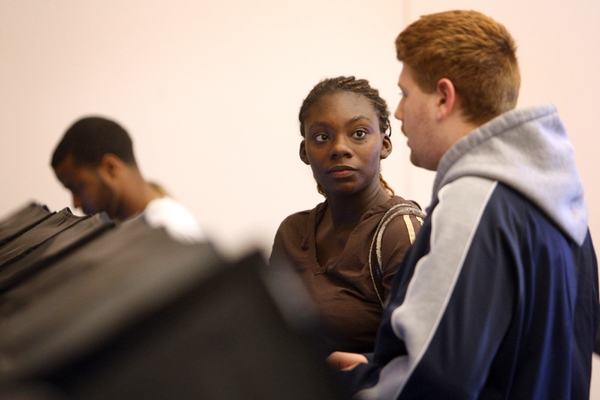 Dijonay Thomas, center, checks with election worker Kenneth Slishman to ...