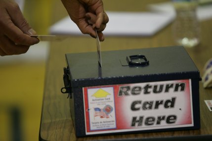 Voters return voting cards after casting their ballots Tuesday in the gymnasium at Basic High School in Henderson.
