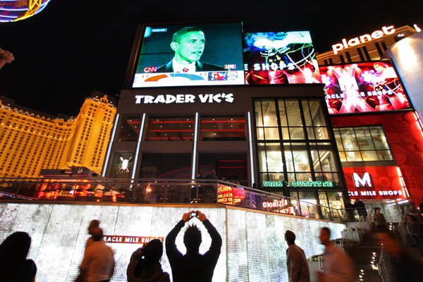 A man takes a photo as pedestrians on the Las ...