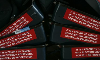 Cases for voting machines rest in a corner at The Lakes Lutheran Church Tuesday.