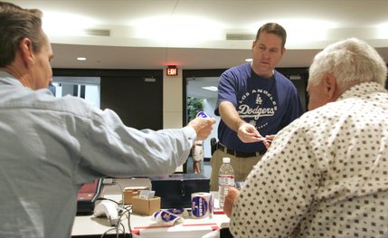Juan Trippe hands over his voting card and gets a sticker after voting at the West Las Vegas Library Tuesday. 