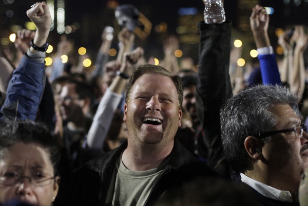 The crowd reacts as it is announced on television that ...